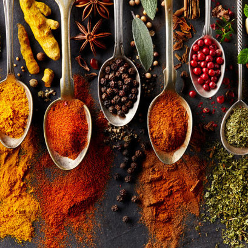 A selection of different spices is presented on spoons