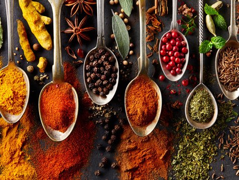 A selection of different spices is presented on spoons