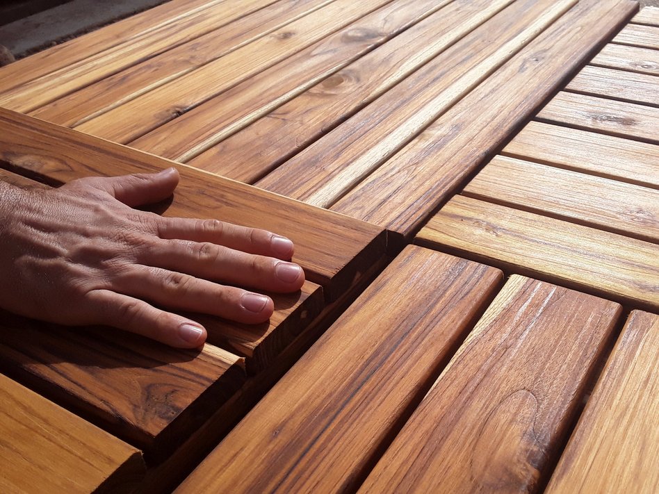 A hand is feeling wooden boards