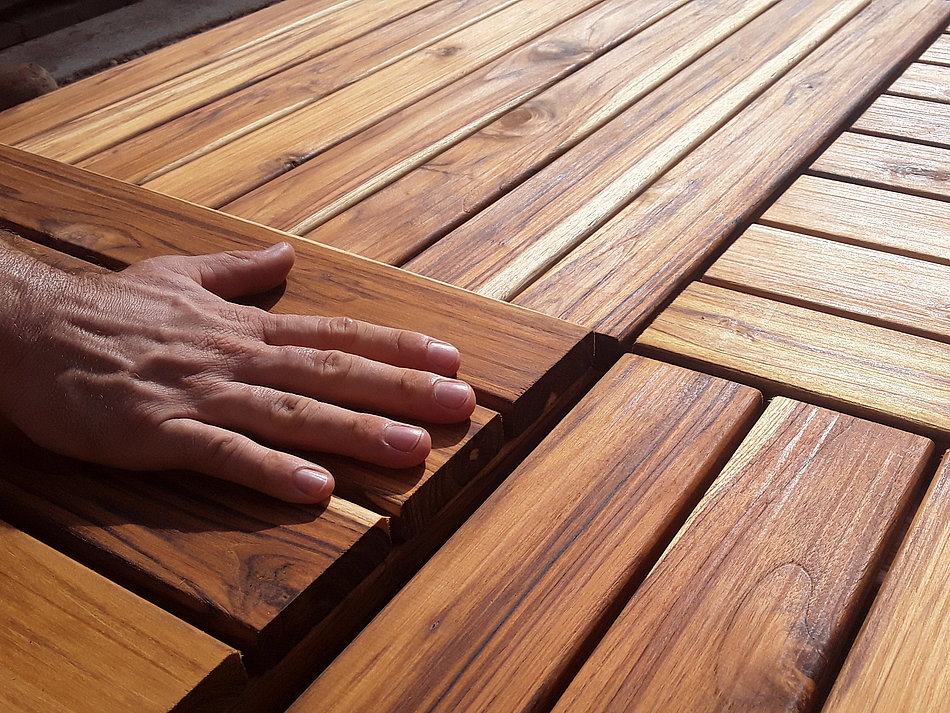 A hand is feeling wooden boards