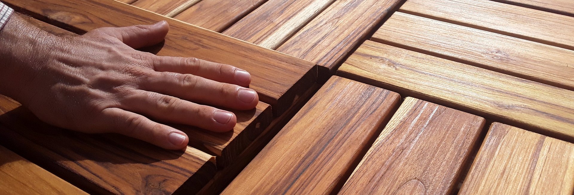 Sustainable wood products offered by IPD exporters A hand is feeling wooden boards